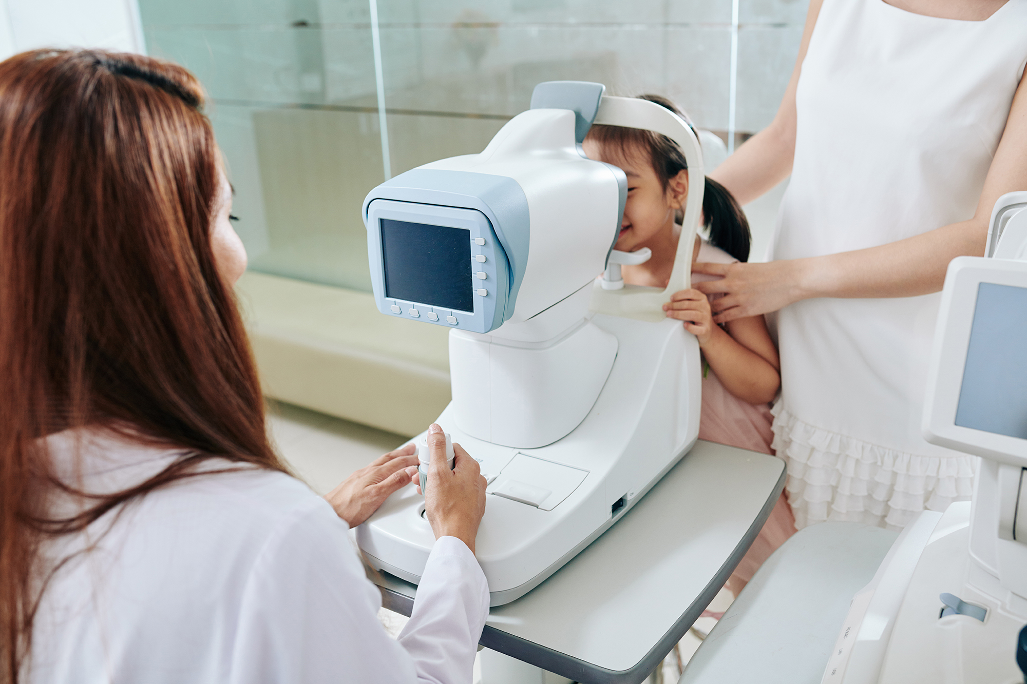 Pediatric ophthalmologist using refractometer eye test